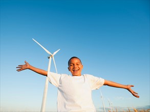 USA, Oregon, Wasco, Boy (8-9) standing in front wind turbine.