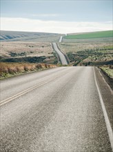 USA, Oregon, Boardman, Rolling landscape with empty road. Photo: Erik Isakson