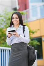 Young businesswoman text-messaging. Photo : Take A Pix Media