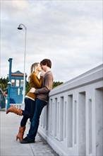 Young couple kissing on bridge. Photo : Take A Pix Media