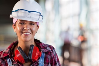 Portrait of female manual worker wearing hardhat. Photo: db2stock