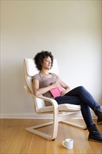 Young woman napping in armchair. Photo : Rob Lewine