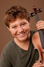 Studio portrait of boy (12-13) playing violin. Photo: Rob Lewine