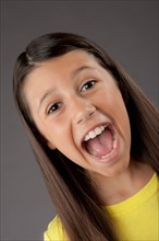 Studio portrait of girl (8-9) screaming. Photo : Rob Lewine