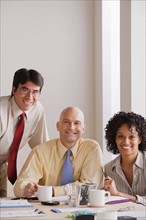 Portrait of smiling business people at meeting. Photo : Rob Lewine