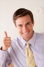 Portrait of businessman with thumbs up. Photo: Rob Lewine