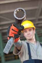 Portrait of male manual worker holding tool. Photo : db2stock