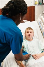 Nurse checking blood pressure to boy (10-11).