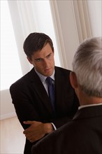 Two business men discussing in office. Photo : Rob Lewine