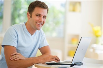 Portrait of young man using laptop.