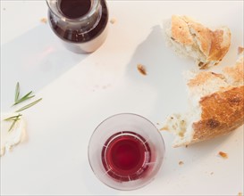 Close up of red wine and bread on table. Photo : Jamie Grill