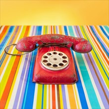 Studio shot of rotary phone on striped background.