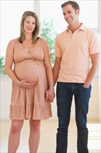 Pregnant woman holding partner's hand.