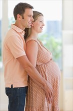 Pregnant woman and her partner standing together.