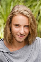 Portrait of young man with long blond hair. Photo : Rob Lewine