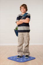 Studio portrait of boy (8-9) carrying backpack. Photo: Rob Lewine
