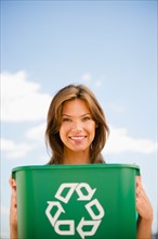 Woman holding recycling bin. Photo : Jamie Grill
