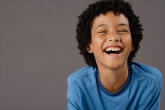 Portrait of laughing boy (8-9), studio shot. Photo : Rob Lewine