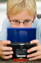 Boy (10-11) playing video game.