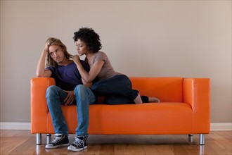Young couple sitting on sofa. Photo: Rob Lewine