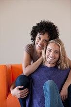 Portrait of young couple sitting on sofa. Photo: Rob Lewine