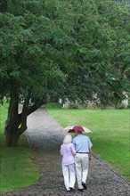 Senior couple walking in park.