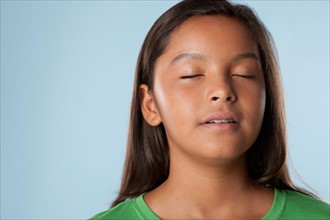 Studio portrait of girl (10-11) with closed eyes. Photo: Rob Lewine