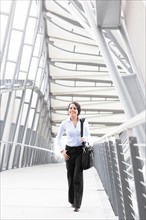 Young businesswoman on walkway. Photo: Take A Pix Media