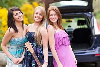 Portrait of young women with guitar by car. Photo : Take A Pix Media