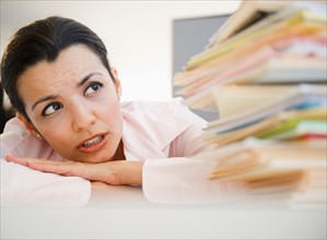 Businesswoman overworked with paperwork. Photo : Jamie Grill