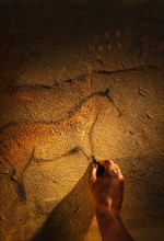 Studio shot of hand making cave painting of horse.