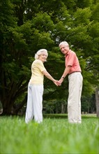 Senior couple standing in park.