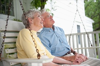 Senior couple sitting on porch swing.