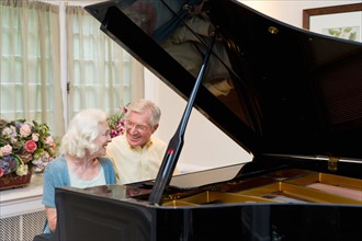 Senior couple playing piano.