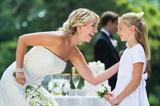 Bride with flower girl (10-11) at wedding reception.
