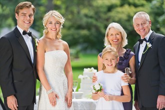 Portrait of married couple, parents and flower girl (10-11).