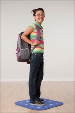 Studio portrait of girl (8-9) carrying backpack. Photo: Rob Lewine