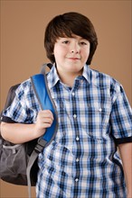 Studio portrait of boy (10-11) wearing backpack. Photo : Rob Lewine