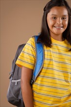 Studio portrait of girl (10-11) wearing backpack. Photo : Rob Lewine