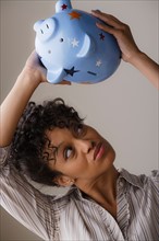 Woman holding piggybank. Photo: Rob Lewine