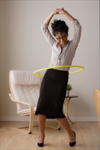 Young businesswoman using hoola hoop. Photo : Rob Lewine