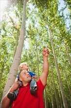 USA, Oregon, Boardman, Father showing son (8-9) poplar trees in tree farm.