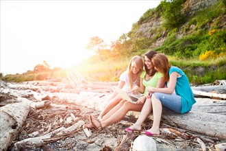 Three young women hanging out on beach. Photo : Take A Pix Media