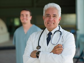 Portrait of senior doctor with orderly in background. Photo: db2stock