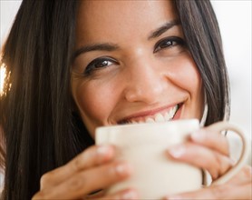 Portrait of smiling woman with cup. Photo : Jamie Grill