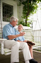 Grandfather and grandson (10-11) sitting on porch swing.
