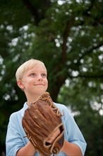 Boy (10-11) wearing baseball glove.
