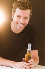 Portrait of young man drinking beer.