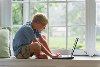 Boy using laptop at home.