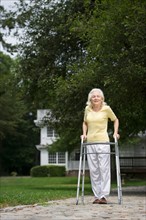 Senior woman walking with walker.
